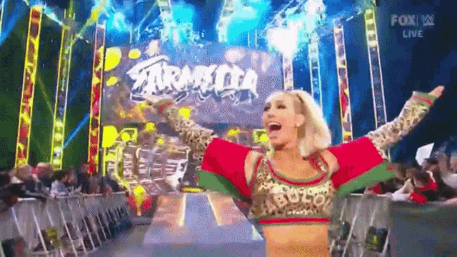 a woman is standing on a stage with her arms outstretched in front of a sign that says fox live .