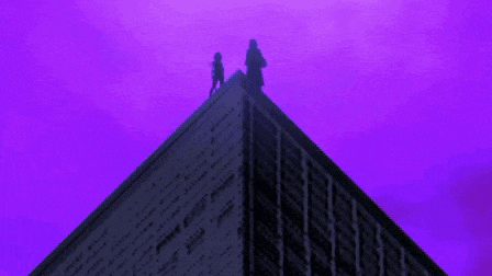 two people standing on top of a building with a purple background