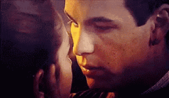 a close up of a man and a woman kissing each other .