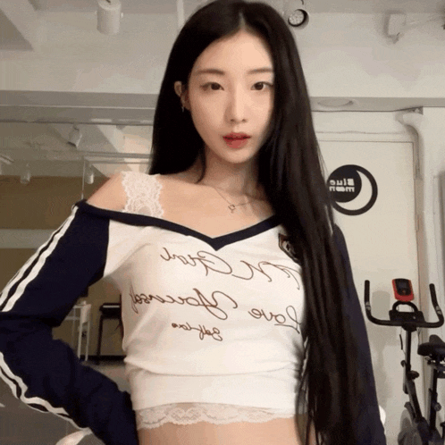 a woman wearing a crop top that says " love yourself " on it