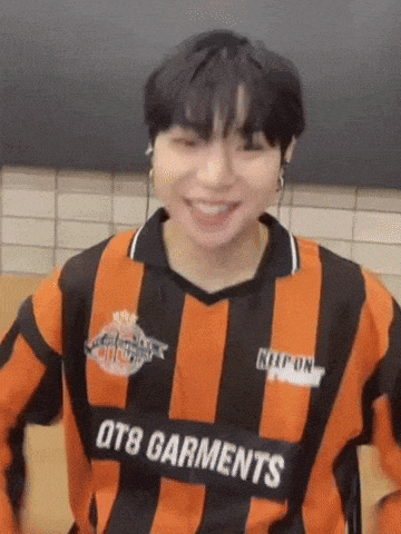 a man wearing an orange and black striped shirt with the word garments on it