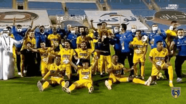 a group of soccer players are posing for a photo on the field .