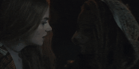 two women kissing in a dark room with one wearing a head scarf