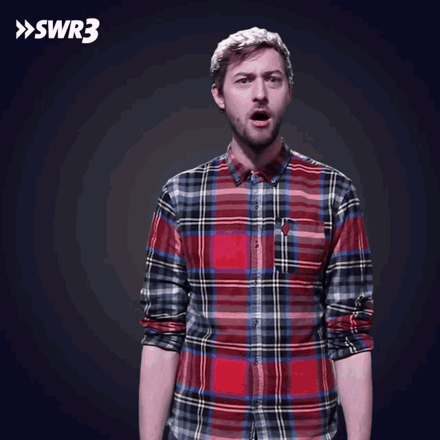 a man wearing a plaid shirt is standing in front of a swr3 logo