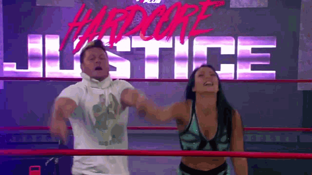 a man and a woman are in a wrestling ring with the word hardcore justice in the background