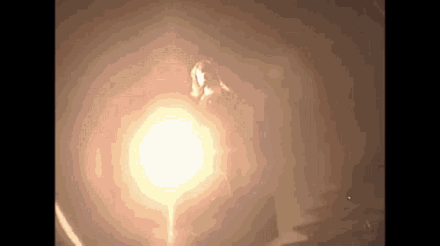 a person is standing in a dark room with a glowing light behind them