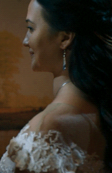a close up of a woman 's face with a painting in the background