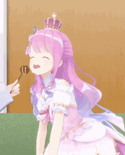 a girl with pink hair and a crown on her head is eating a piece of chocolate