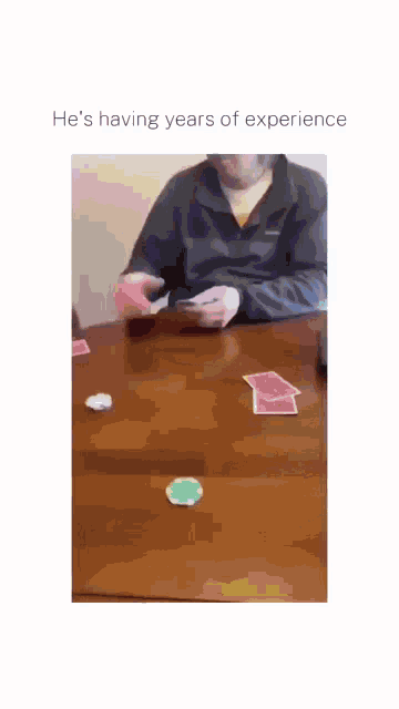 a man in a yellow sweatshirt is sitting at a table with a blue water bottle on it .
