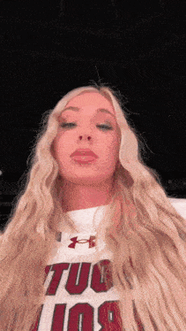 a woman with long blonde hair is wearing a shirt that says tulsa on it