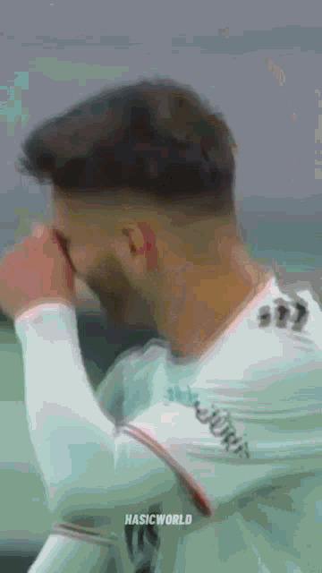 a close up of a soccer player covering his eyes