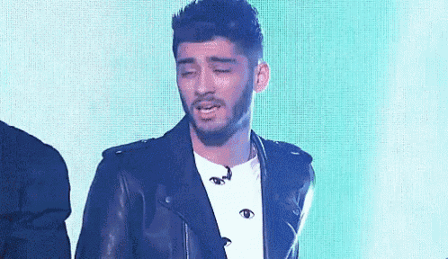 a man wearing a leather jacket and a white shirt is crying .
