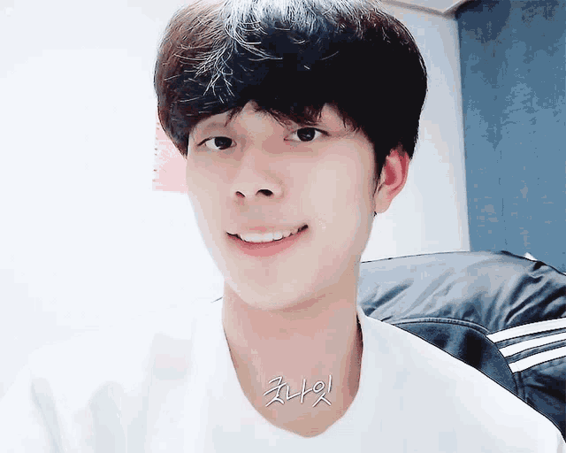 a close up of a young man 's face with korean writing on his chest
