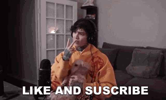 a man wearing headphones is sitting on a couch holding a dog and says like and suscribe .