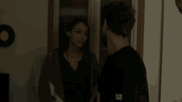a man and a woman are kissing and the man is wearing a shirt with the word wave on it