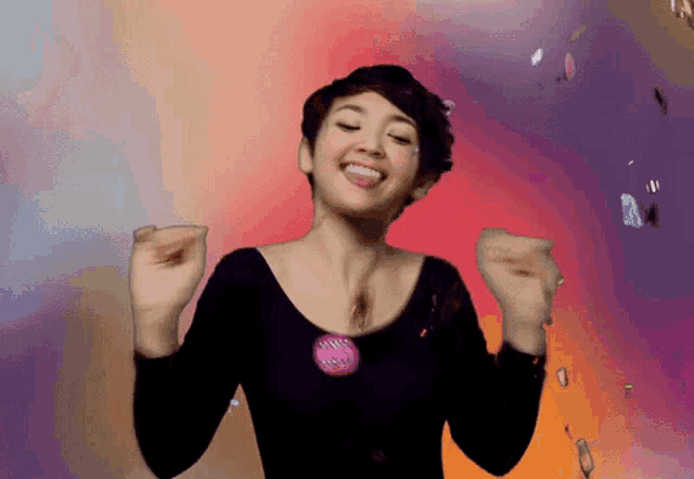 a woman wearing a black top with a pink button that says ' i love you '