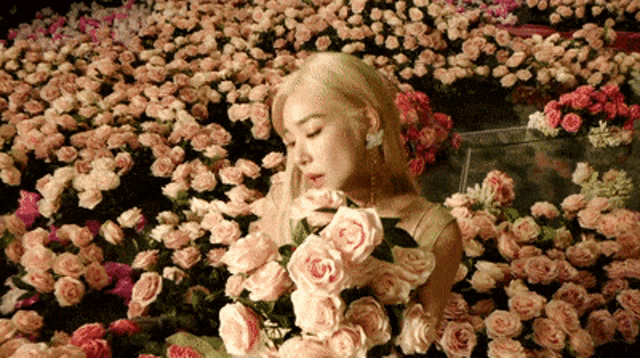 a woman is laying in a field of pink flowers
