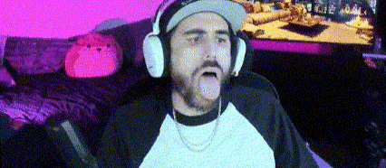 a man wearing headphones and a hat is sticking his tongue out in front of a television .