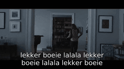 a woman standing in a dark room with the words lekker boie lalala lekker boie lalala lekker boie