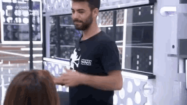 a man with a beard is standing next to a woman in a room .