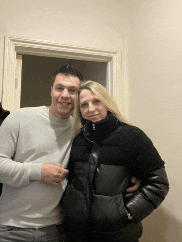 a man and woman are posing for a picture in a doorway