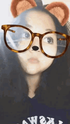 a girl wearing glasses and bear ears looks at something