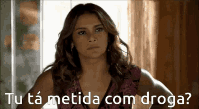 a woman says tu ta metida com droga while standing in front of a window