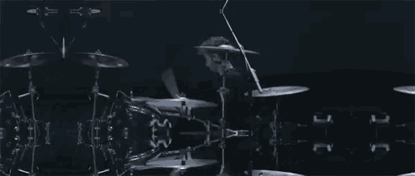 a man is playing drums on a stage with a microphone .