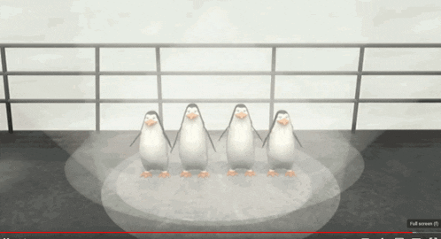 four penguins are standing on a stage in front of a full screen