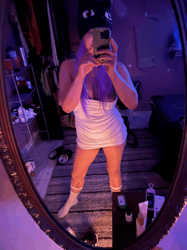 a woman with purple hair takes a selfie in a mirror