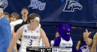 a man in a high point jersey stands next to a mascot