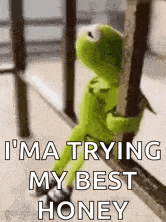 kermit the frog is sitting on a railing and holding onto a railing .