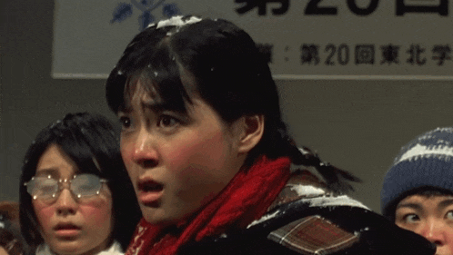 a girl with snow on her face stands in front of a sign that says 20 on it