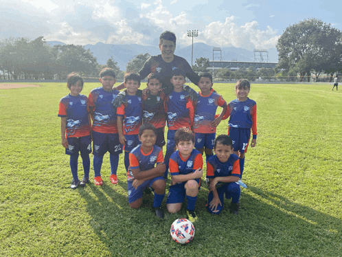 a soccer team poses for a photo with a ball