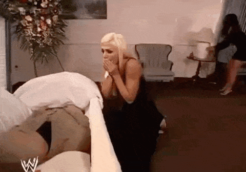 a woman is kneeling next to a coffin in a church .