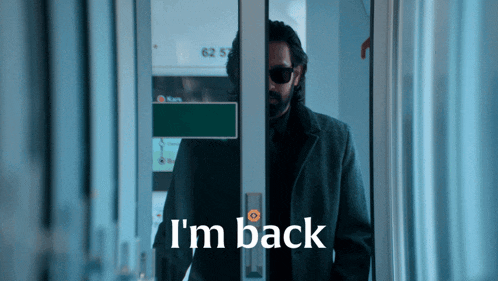 a man standing in a doorway with the words " i 'm back " on the bottom