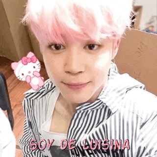 a man with pink hair is taking a selfie with a hello kitty sticker .