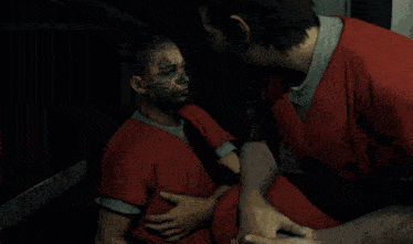 a man in a red shirt is talking to another man in a red shirt