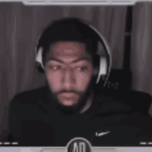 a man wearing headphones is sitting in front of a screen that says ao
