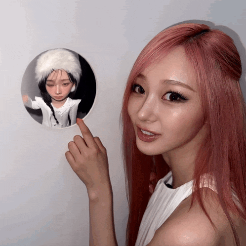 a woman with red hair points to a picture of a girl