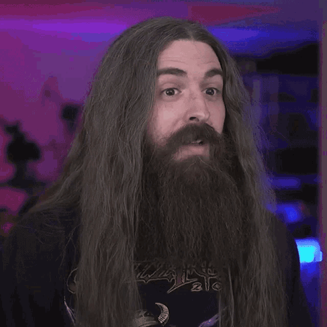 a man with long hair and a beard has the word explosive in front of him
