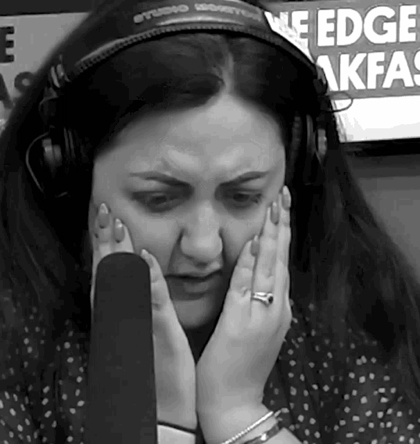 a woman wearing headphones is covering her face in front of a sign that says edge