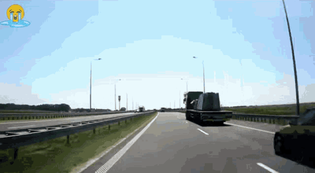 a car is driving down a highway with a sad face on the bottom right