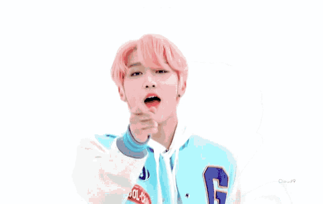 a young man with pink hair is wearing a blue jacket with the letter g on the front .