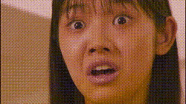a close up of a woman 's face with a surprised look on her face