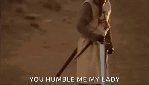 a man in a white robe is holding a sword in the desert and says `` you humble me my lady '' .