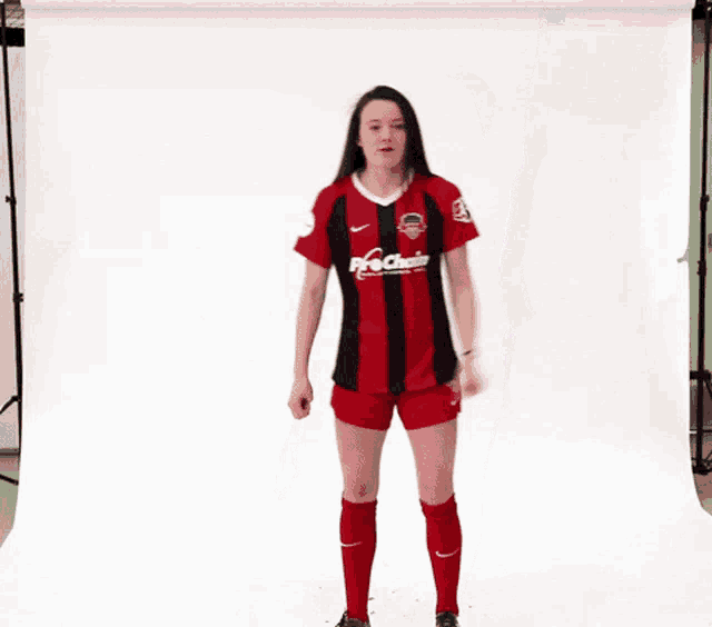 a woman wearing a red and black shirt that says fc chain