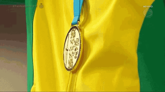a close up of a medal on a yellow and green shirt