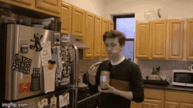 a man standing in front of a fridge with a sticker that says ' imgflip.com '