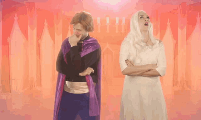 a man in a purple cape and a woman in a white dress stand next to each other with their arms crossed